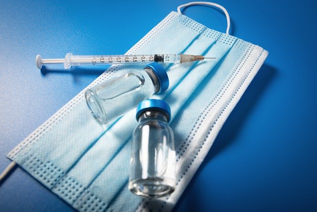 a blue mask, glass vial, and medical syringe