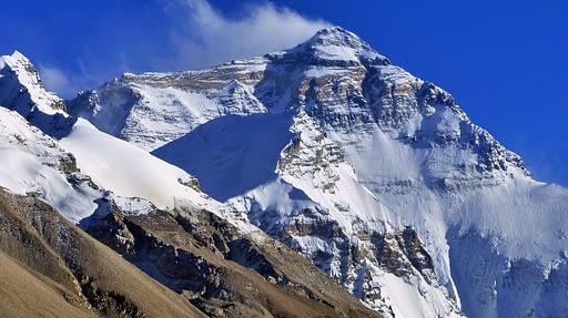 Image of a rocky mountain peak covered in snow.