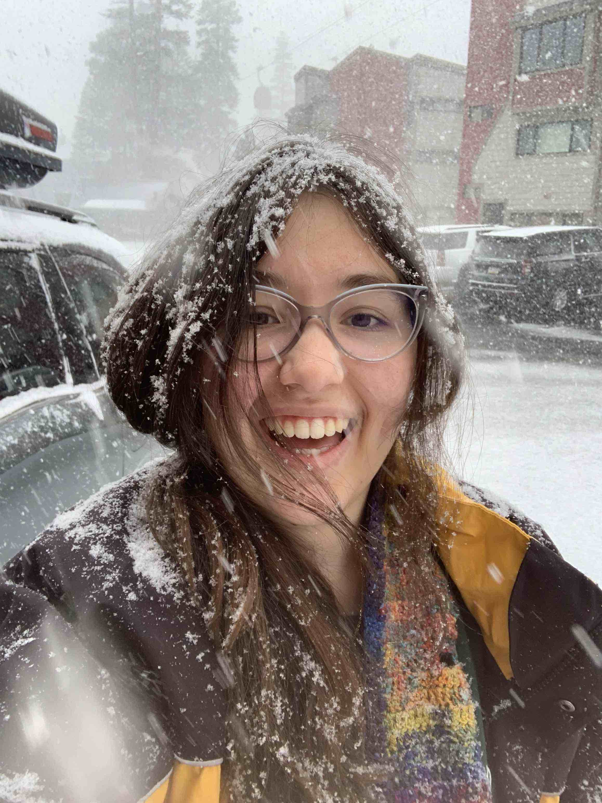 Clarissa Lesky, a young woman with long brown hair, standing outside as snow is falling down around her
